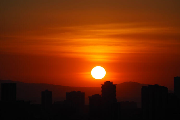 オレンジ色に染まる海と都市景観のコントラスト